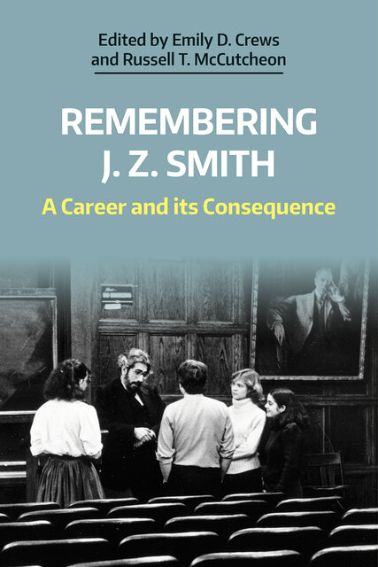 Photo of Smith talking with 4 students in a lecture hall