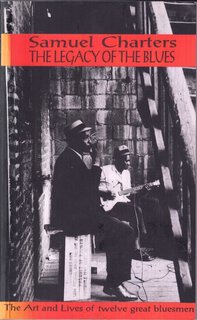 Photo (possibly 1950s)of two men sitting outside on a bench one playing harmonica, the other electric guitar