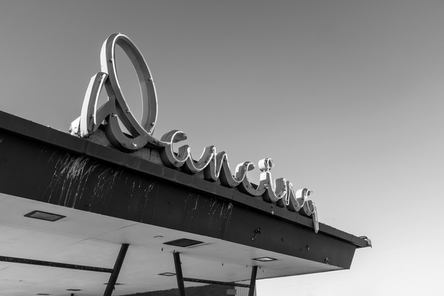 neon sign of word dancing on top of mid-century building 