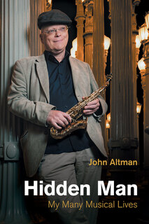 photo of author standing holding a sax and wearing a hat