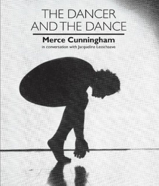 Photo of Cunningham on bent knees, looking down, on toes with hands clasped together close to floor