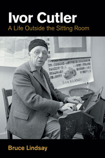 photo of Ivor at an upright piano wearing hat