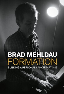 photo of Brad at the piano, looking down as he strikes keys